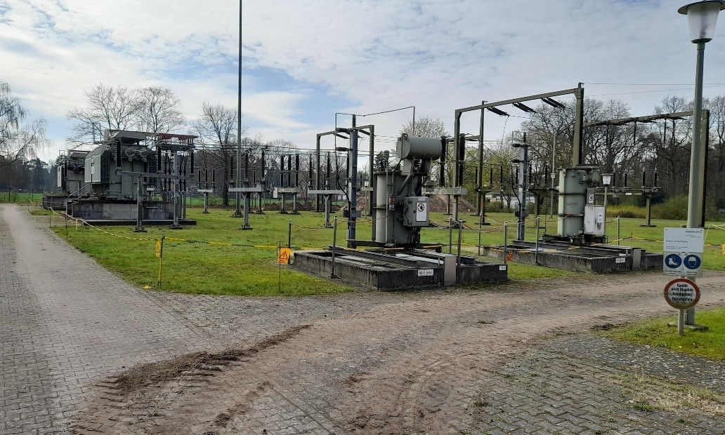 Image of an older substation with green meadows and equipment