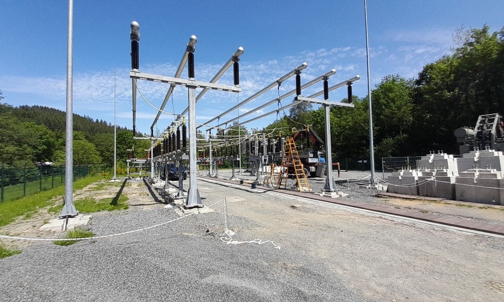 Image of a substation under construction with modern equipment and a concrete ground