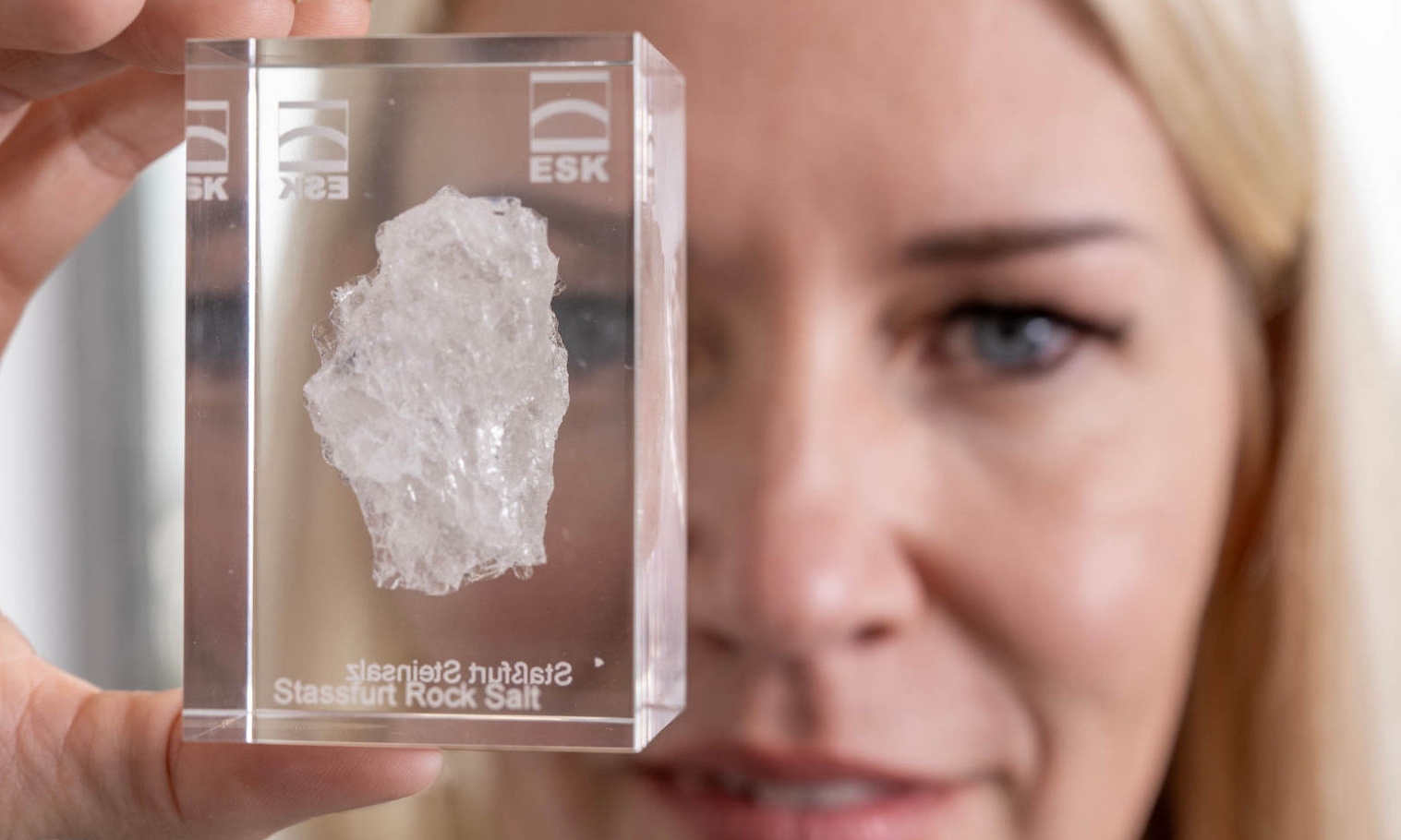 Andrea Wobito holds an acrylic glass in front of the camera, in which a piece of rock salt from Staßfurt embedded in it