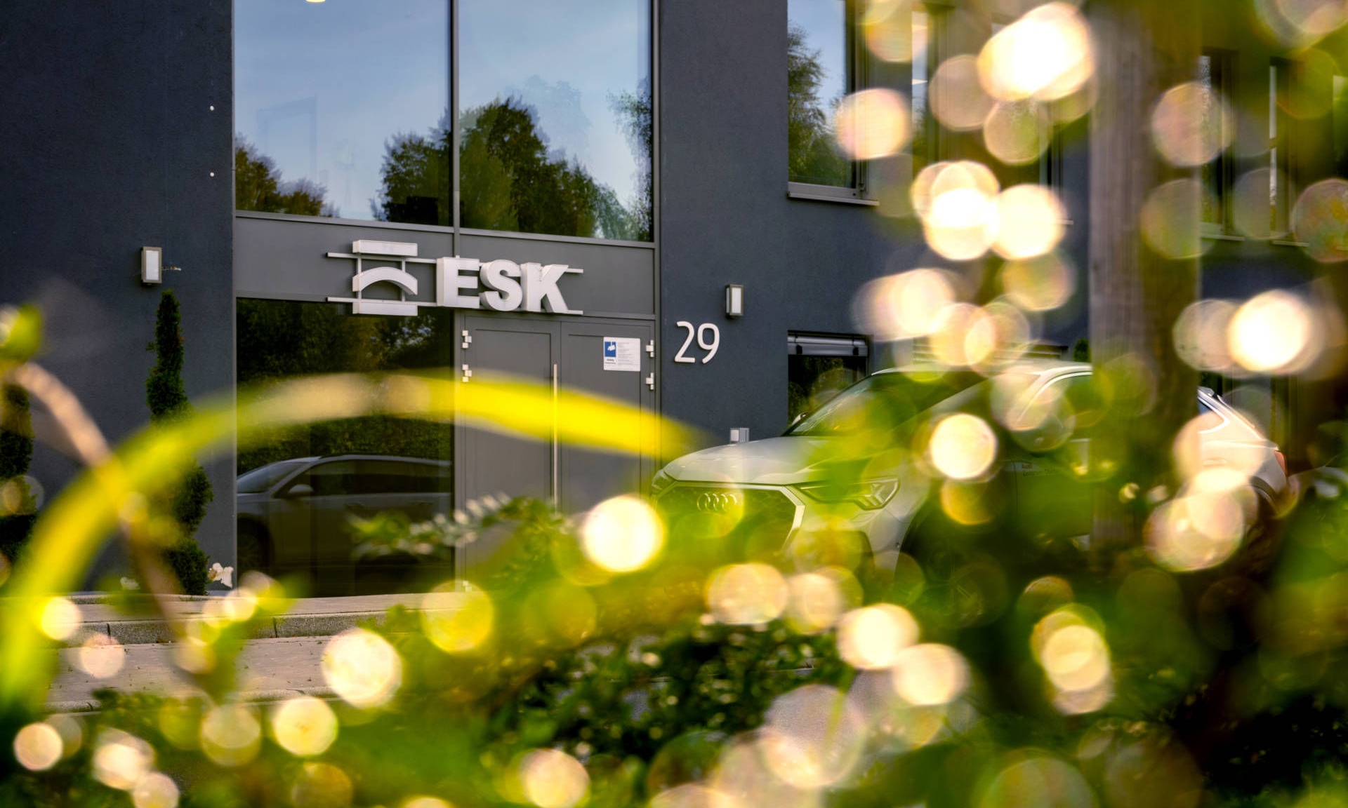 Entrance of the anthracite-colored office building of ESK GmbH in Holzwickede with reflective light in the foreground