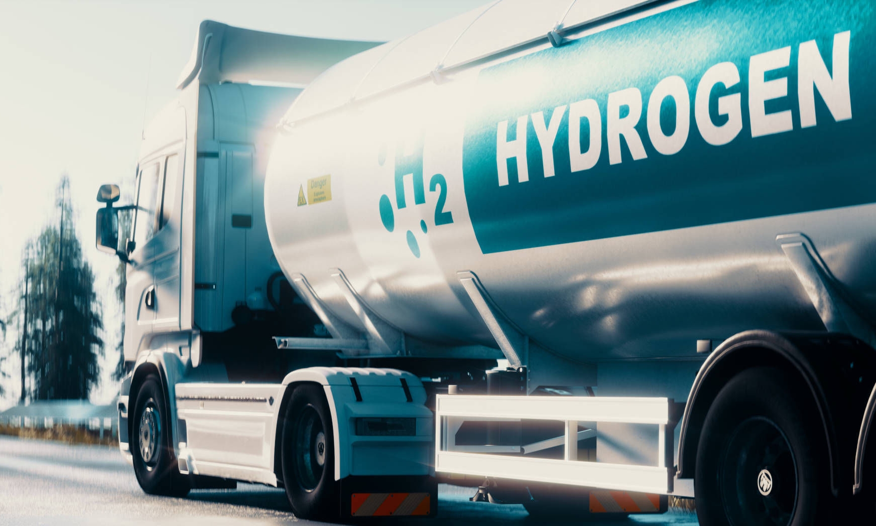 Truck with a hydrogen tank that has "H2 HYDROGEN" written on it, on a road in a rural setting