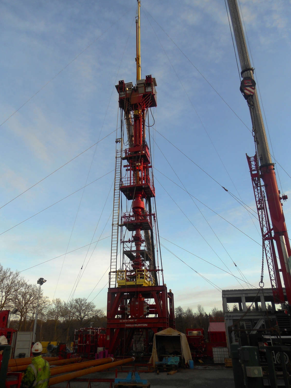 Workover rig secured with ropes at a gas storage facility in evening light