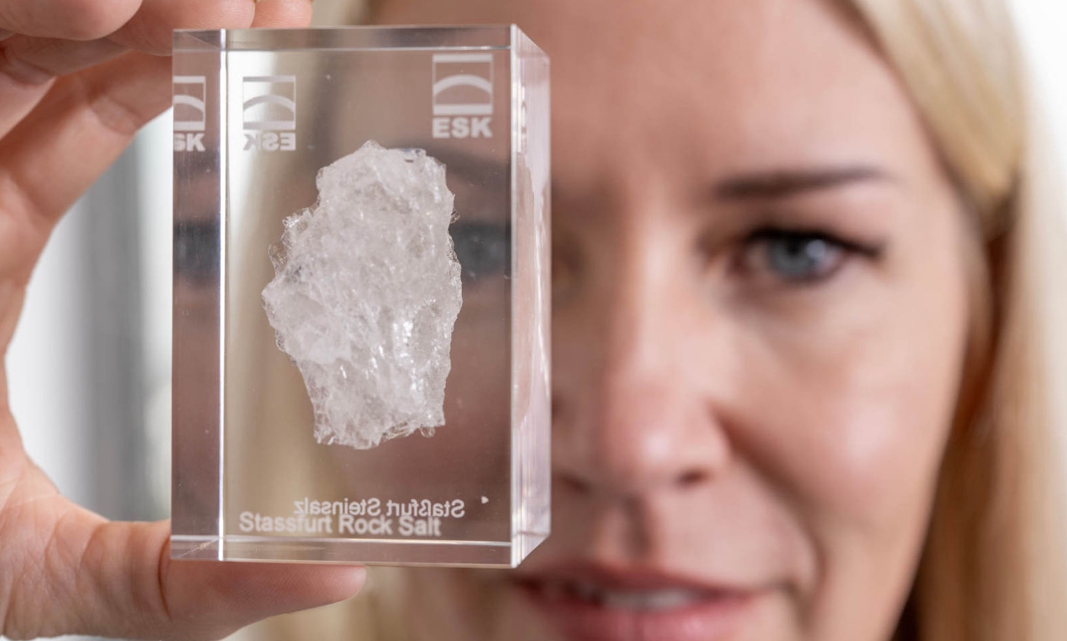 Andrea Wobito holds an acrylic glass in front of the camera, in which a piece of rock salt from Staßfurt embedded in it